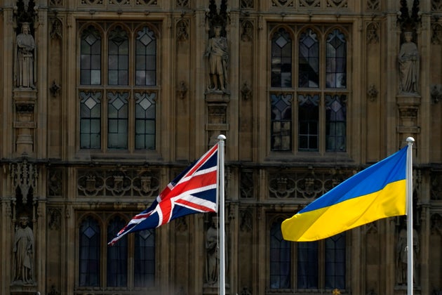 A Union Jack flag and a Ukraine flag fly in front of the Houses of Parliament