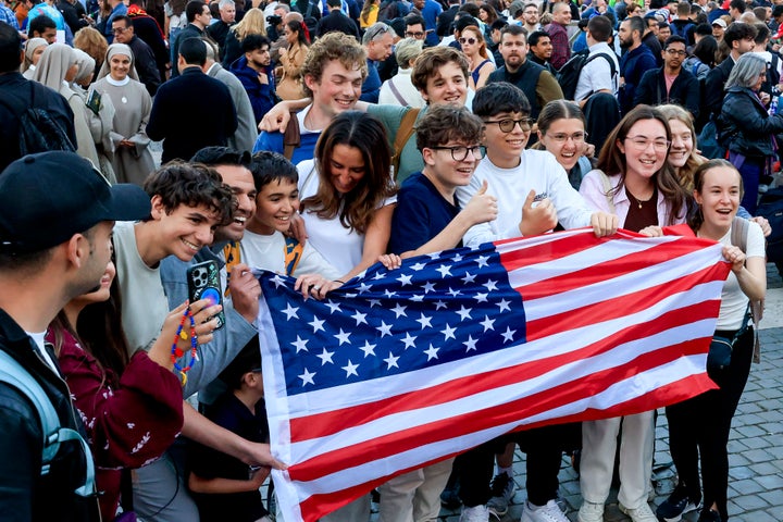 People hold an American flag during the speech of the new Pope Leo 14th, Archibishop of Chicago Robert Francis Prevost, after his election Thursday.