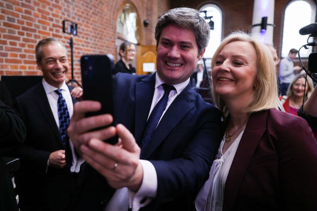 Nigel Farage looks on as Liz Truss poses for a selfie at the launch of Popular Conservatism last year.
