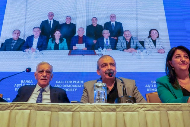 Μέλη αντιπροσωπείας του φιλοκουρδικού Κόμματος Ισότητας και Δημοκρατίας των Λαών, ή DEM, δημοσιεύουν δήλωση του φυλακισμένου ηγέτη του ανταρτικού Εργατικού Κόμματος του Κουρδιστάν, ή PKK, Αμπντουλάχ Οτσαλάν, στο κέντρο της φωτογραφίας στο φόντο, στην Κωνσταντινούπολη, Τουρκία, Πέμπτη 27 Φεβρουαρίου 2025. (AP Photo/Khalil Hamra)