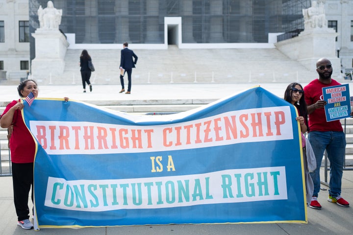 Activists begin to gather with signs at the U.S. Supreme Court before the court hears oral arguments on May 15 on President Donald Trump's birthright citizenship executive order.