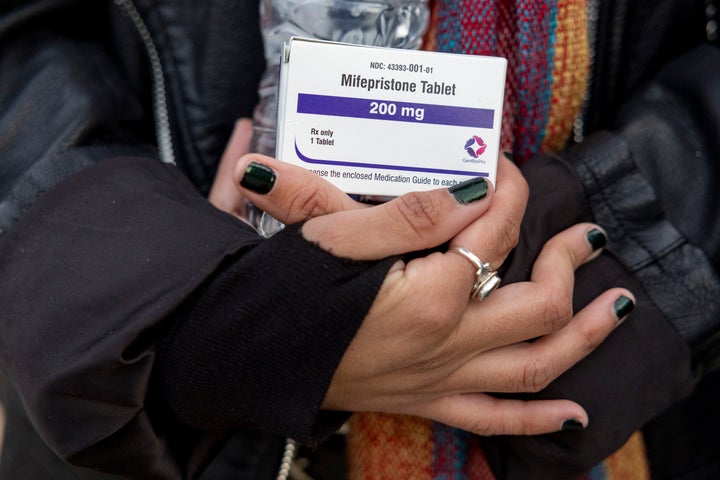 An abortion rights activist holds a box of mifepristone pills during a demonstration outside the Supreme Court in March 2024.