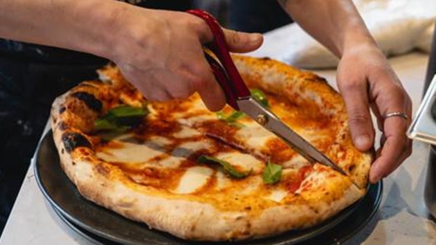 Forbici chef cutting pizza with scissors