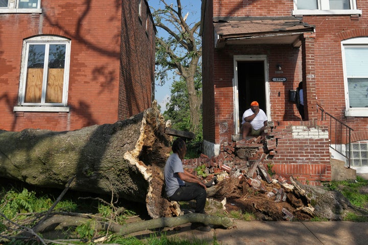People survey damage after a severe storm moved through Friday, May 16, 2025, in St. Louis. (AP Photo/Jeff Roberson)