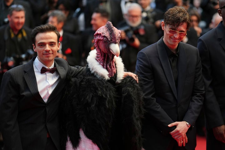 Raphael Quenard, left, and Hugo David, right, pose with a person dressed in bird costume upon arrival at the premiere of the film 'Die, My Love' at the 78th international film festival, Cannes, southern France, Saturday, May 17, 2025. (Photo by Lewis Joly/Invision/AP)