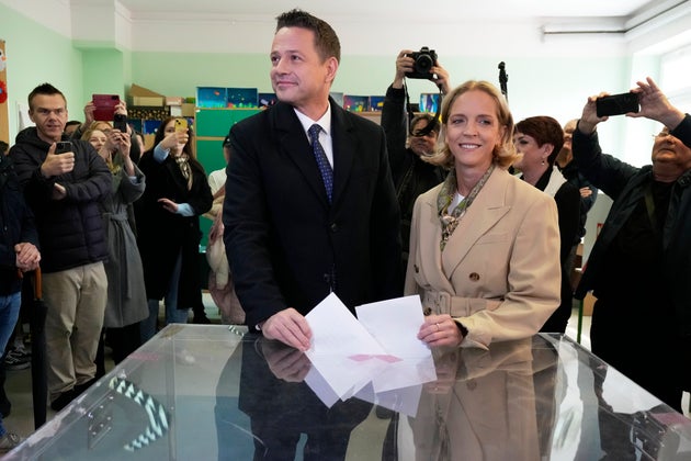 Ο υποψήφιος πρόεδρος, δήμαρχος της Βαρσοβίας και μέλος του κυβερνώντος κεντρώου κόμματος Συνασπισμός Πολιτών Rafal Trzaskowski και η σύζυγός του Malgorzata Trzaskowska ψηφίζουν σε εκλογικό κέντρο στη Βαρσοβία, Κυριακή 18 Μαΐου 2025. (AP Photo/Czarek Sokolowski)