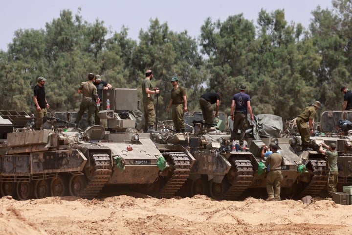 Israeli troops work on their tanks by Israel's border with Gaza on May 18, 2025. Israel's military has announced a day earlier the expansion of its operations, saying its aims include "achieving all the war's objectives" like releasing hostages and "the defeat of Hamas."