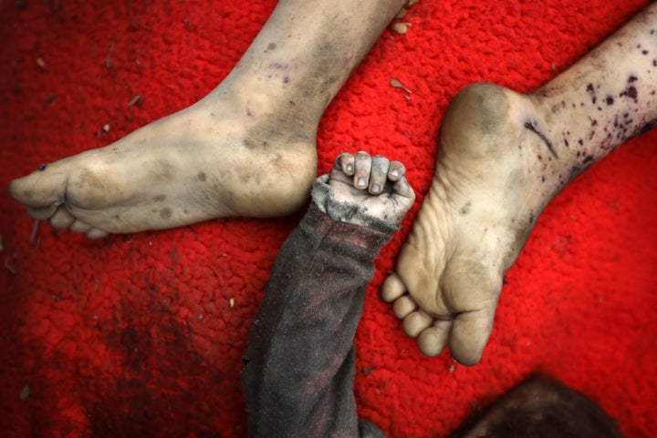 The bodies of two Palestinian children killed in an Israeli airstrike on northern Gaza lie in the courtyard of Al-Shifa Hospital in Gaza City, on May 18, 2025.