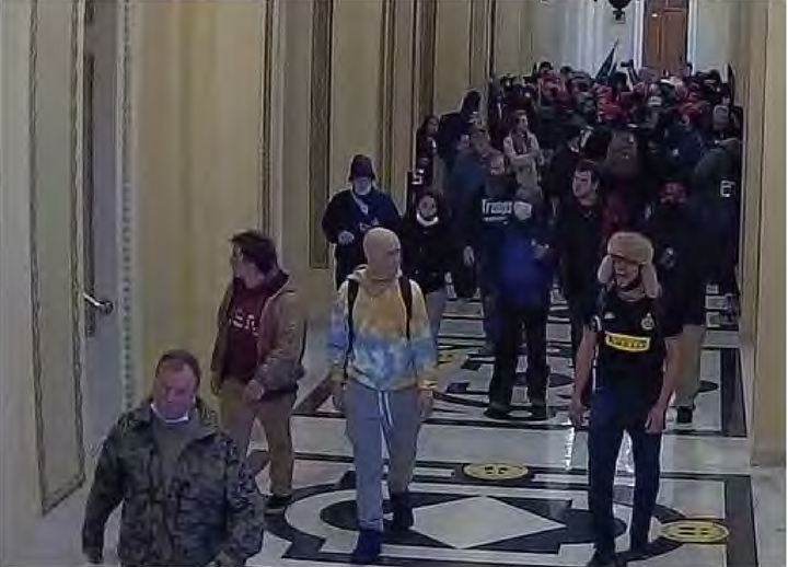 Zachary Jordan Alam, seen in the hat on the right, was sentenced last year to eight-year in prison for assaulting police officers and breaking windows during the 2021 Capitol attack.