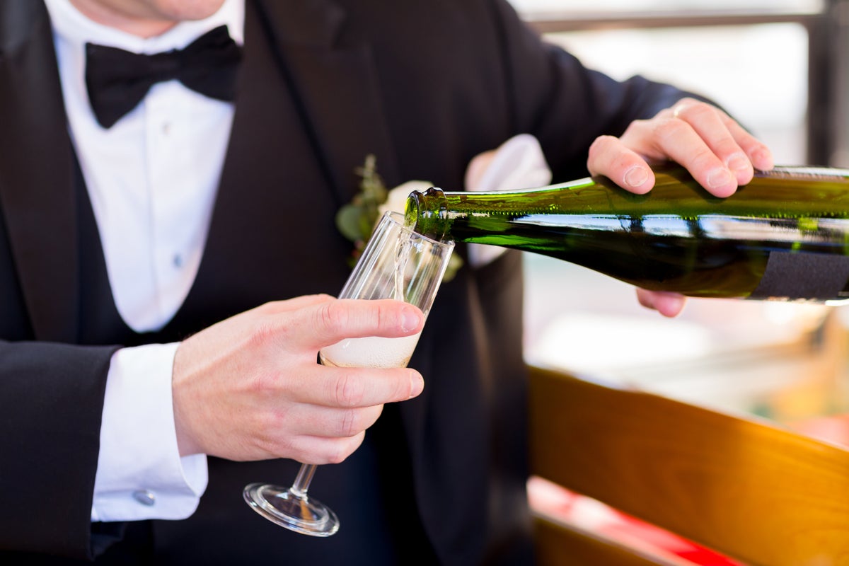 Man in tuxedo pouring a glass of champagne