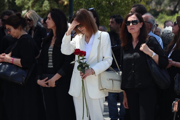 Η Κάτια Δανδουλάκη στα λευκά, κρατώντας δύο κόκκινα τριαντάφυλλα. Γαλανός και Δανδουλάκη υπήρξαν στο παρελθόν ζευγάρι. 