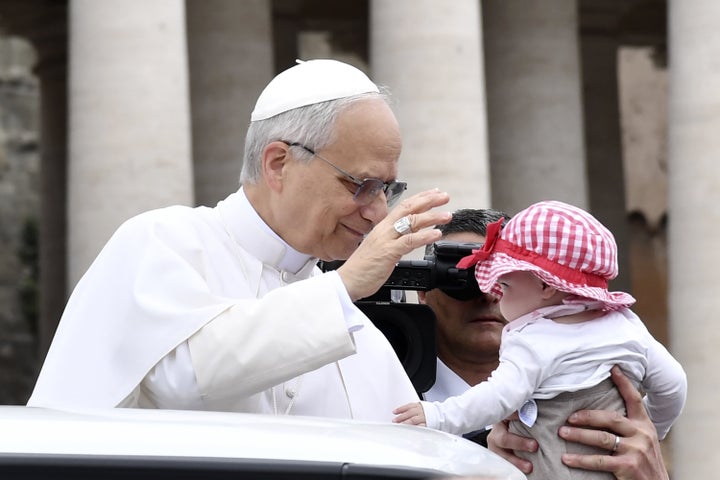 Pope Leo XIV greets a baby as he arrives at his first general audience in St. Peter's Square at the Vatican on May 21, 2025. The new pope spoke out specifically against the worsening humanitarian crisis in Gaza, calling on Israel to allow 