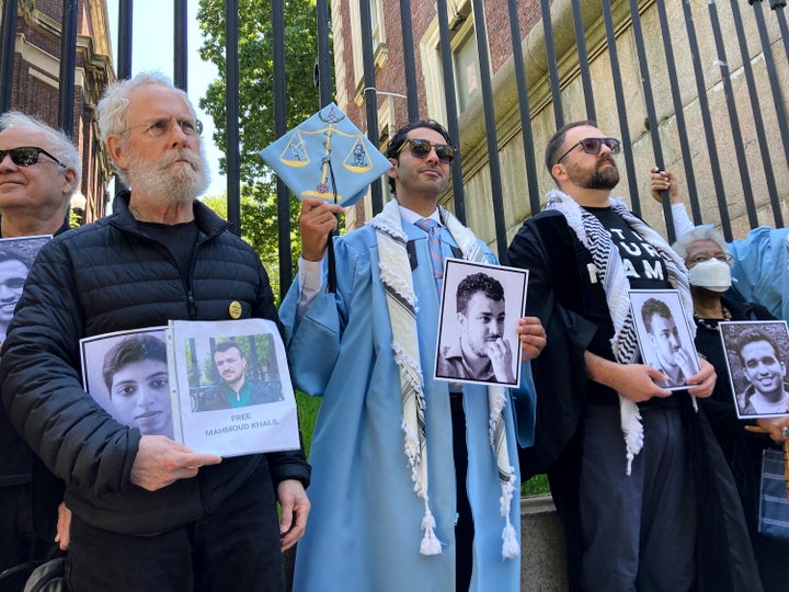 Mohsen Mahdawi holds a photo of Mahmoud Khalil while posing for a photo with demonstrators outside the gates of Columbia University after graduating, on Monday, May 19, 2025, in New York.