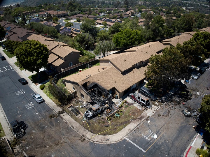 Debris covers the ground after a small plane crashed into a San Diego neighborhood, setting homes and cars on fire and forcing evacuations early Thursday, May 22, 2025. (AP Photo/William Liang)