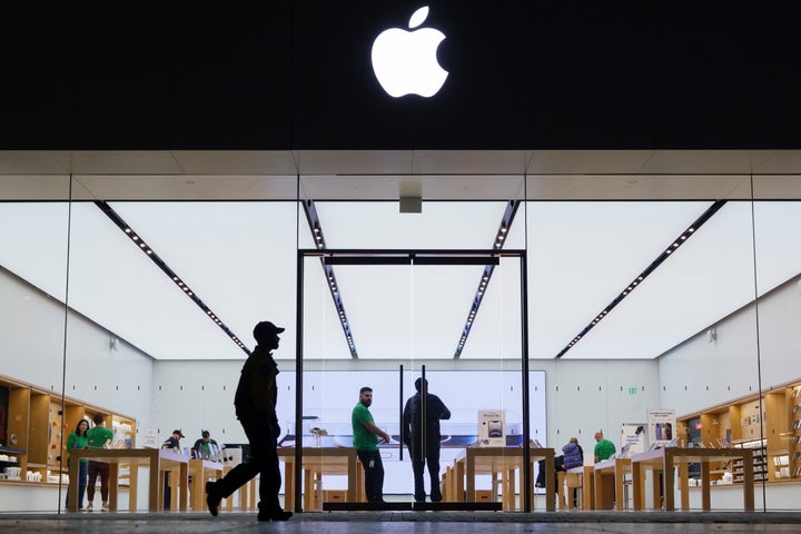 A shopper walks a dog by an Apple store at the Westfield UTC shopping center on May 1, 2025 in San Diego, California. (Photo by Kevin Carter/Getty Images)