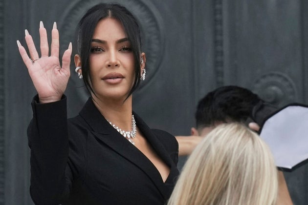 Η Kim Kardashian χαιρετά καθώς φτάνει για να καταθέσει σχετικά με τη ληστεία κοσμημάτων της από το δωμάτιο του ξενοδοχείου της στο Παρίσι το 2016, στο Παρίσι, Τρίτη 13 Μαΐου 2025. (AP Photo/Aurelien Morissard, File)