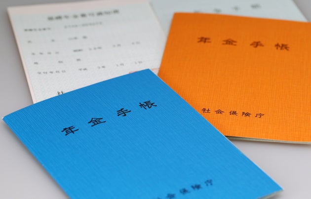 日本年金機構が運営する公的年金制度（国民年金・厚生年金・船員保険）の加入者に発行される年金手帳（表紙がオレンジ色は基礎年金番号が導入された1997年以前に発行された物、青色はそれ以降に発行された物）。基礎年金番号など個人情報が記載されている（2015年撮影）