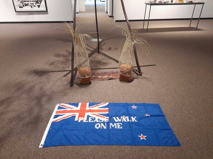 A New Zealand flag printed with the words “please walk on me” and laid on the floor of an art gallery has once again been packed away following public outcry, 30 years after protests forced the removal of the same artwork. (Catherine Hubbard/Nelson Mail/STUFF via AP) qhiukiuiqkeinv