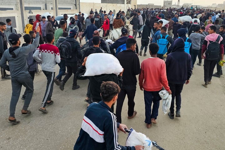 Displaced Palestinians, some carrying sacks of food, leave a distribution centre in Rafah, in the southern Gaza Strip, on Sunday.