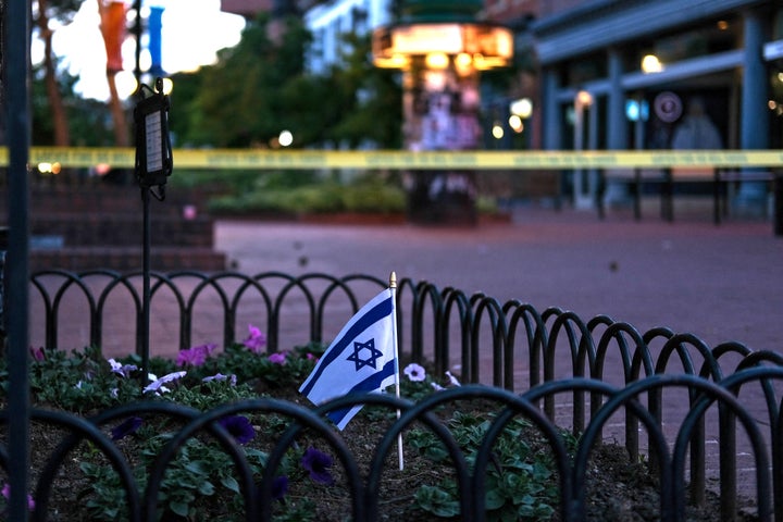 An Israeli flag stands Sunday in a bed of flowers in Boulder, Colorado, as caution tape blocks off the scene of an attack on demonstrators calling for the release of Israeli hostages held in Gaza.