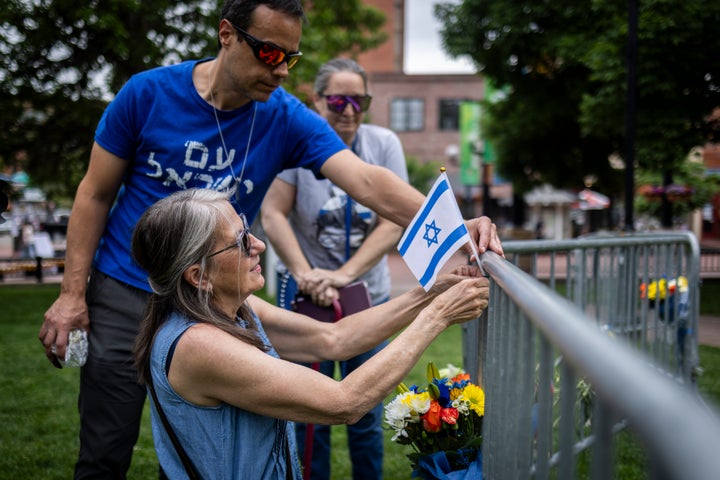 Lisa Turnquist lays flowers and an Israeli flag at the site of a recent attack outside the Boulder County Courthouse on June 2, 2025, in Boulder, Colorado. Authorities arrested Mohamed Sabry Soliman after he reportedly threw incendiary devices at a group participating in a weekly demonstration in solidarity with the remaining Israeli hostages in Gaza.