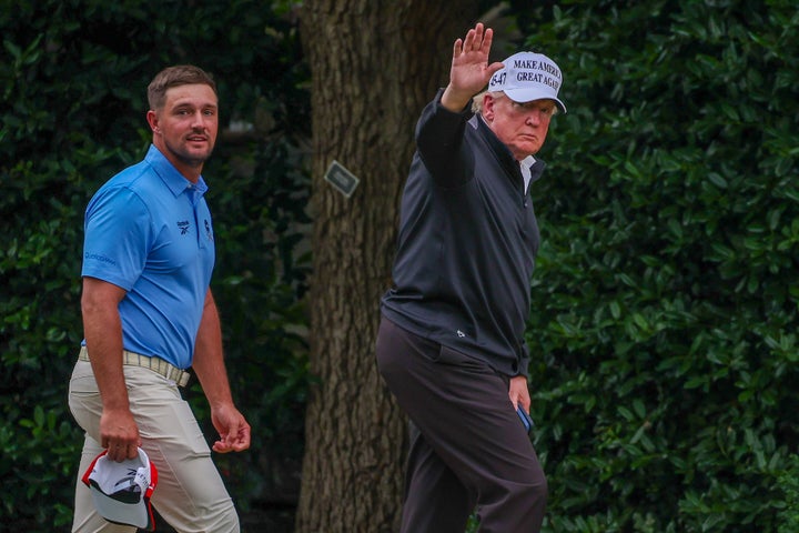 Trump waves with DeChambeau in tow after they appeared at Trump National Golf Club.
