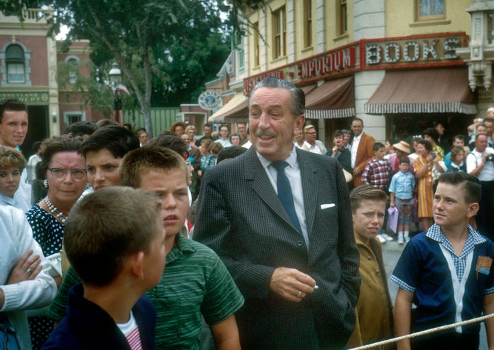 American film producer and studio executive Walt Disney stands with a group of children and adults as they wait for a parade on Main Street USA at Disneyland in Anaheim, California, in 1962.
