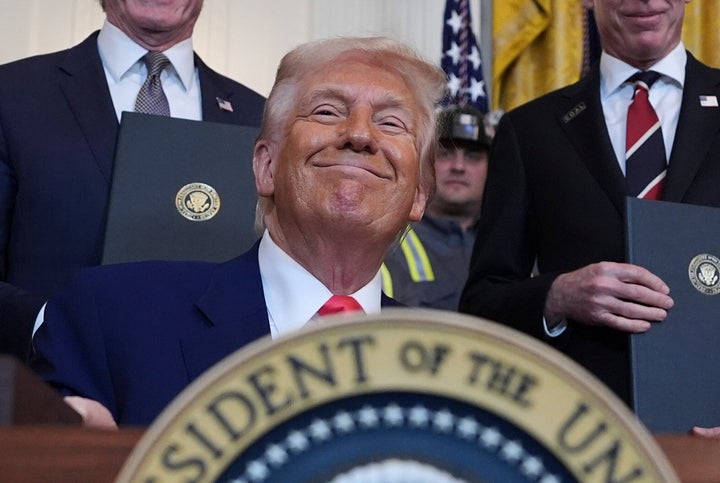 O presidente Donald Trump sorri enquanto assina ordens executivas em abril.