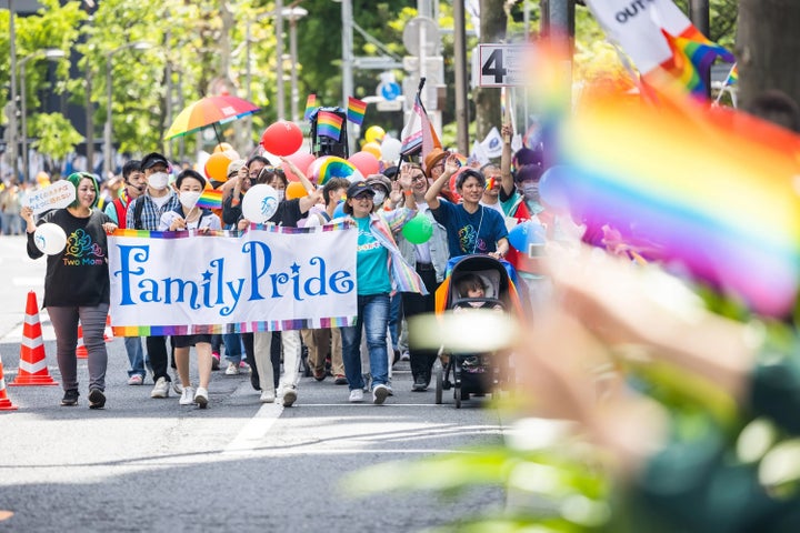 「Family Pride」の横断幕を掲げ歩く、2023年のパレード参加者