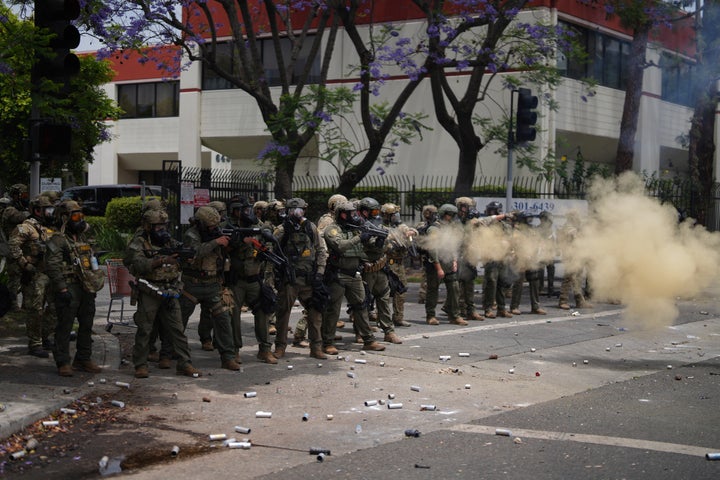 O pessoal da patrulha de fronteira implanta gás lacrimogêneo durante uma demonstração sobre as dezenas detidas em uma operação pelas autoridades federais de imigração no dia anterior, em Paramount, Califórnia, sábado, 7 de junho de 2025. (AP Photo/Eric Thayer)