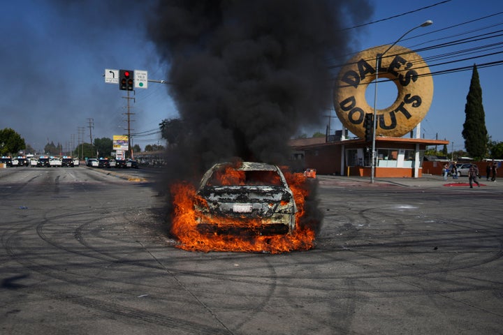 Um carro queima durante um protesto em Compton, Califórnia, sábado, 7 de junho de 2025, depois que as autoridades federais de imigração conduziram operações. (AP Photo/Eric Thayer)