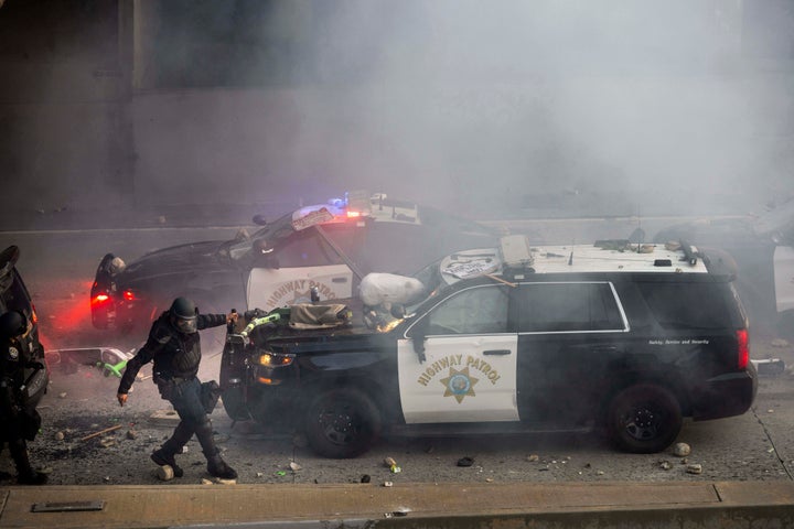 Un oficial de la Patrulla de Carreteras de California saca un scooter eléctrico de un vehículo en una carretera mientras los manifestantes arrojan objetos a los vehículos policiales cerca del Centro de Detención Metropolitana en el centro de Los Ángeles, el 8 de junio de 2025.