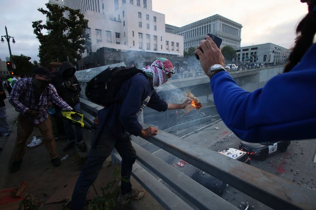 Διαδηλωτές ρίχνουν αντικείμενα στα οχήματα της αστυνομίας σε αυτοκινητόδρομο κοντά στο Μητροπολιτικό Κέντρο Κράτησης στο κέντρο του Λος Άντζελες, την Κυριακή 8 Ιουνίου 2025. (AP Photo/Ethan Swope)