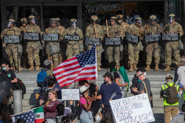Demonstrators face California National Guard members standing guard outside the Federal Building as they protest in response to federal immigration operations in Los Angeles.