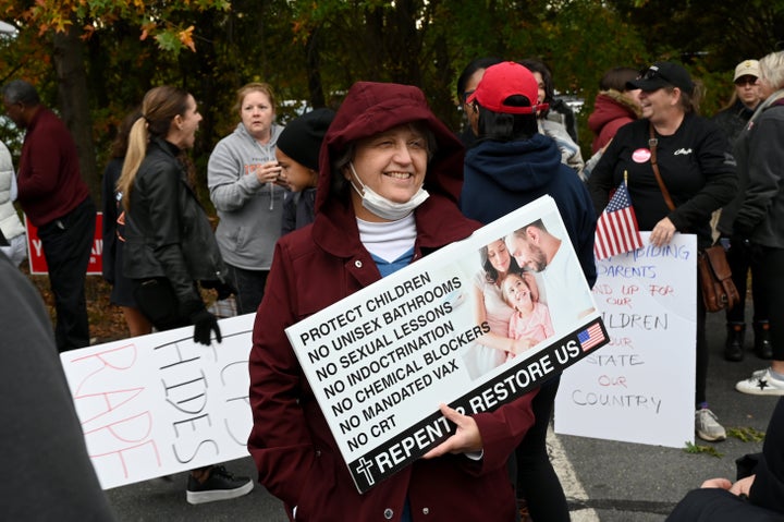 A woman holds a sign listing conservative talking points ahead of a school board meeting in Loudoun County, Virginia.