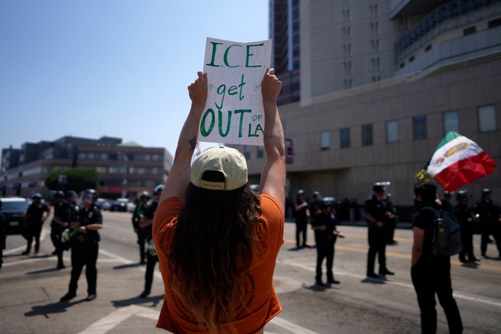 A protester photographed holding up a sign in front of the Metropolitan Detention Center in downtown Los Angeles on Monday.