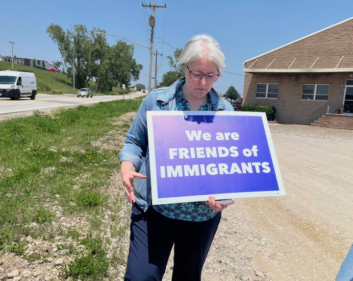 Sara Schulte-Bukowinski, líder da fé em Omaha, Nebraska, detém uma placa protestando contra um ataque de imigração, terça-feira, 10 de junho de 2025, na Glenn Valley Foods, uma fábrica de embalagens de carne no sul de Omaha.