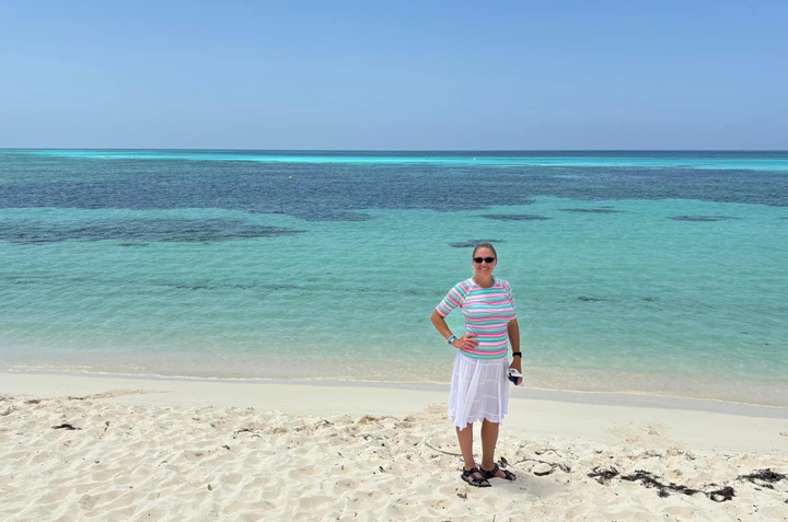 The author poses on a beach in Cozumel, Mexico, where she met a stranger from England who shared her menopause struggles.