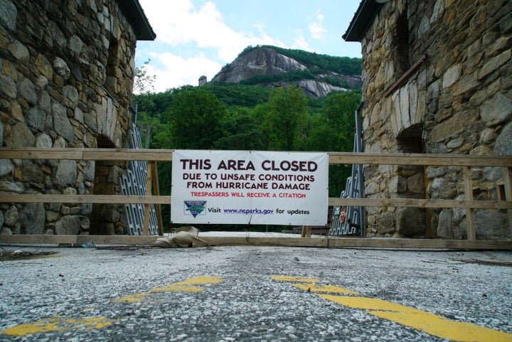 Parts of North Carolina continue to rebuild after Hurricane Helene ripped through the area. A sign warns visitors of a hurricane-damaged bridge at the entrance to the state park in Chimney Rock Village on May 14.