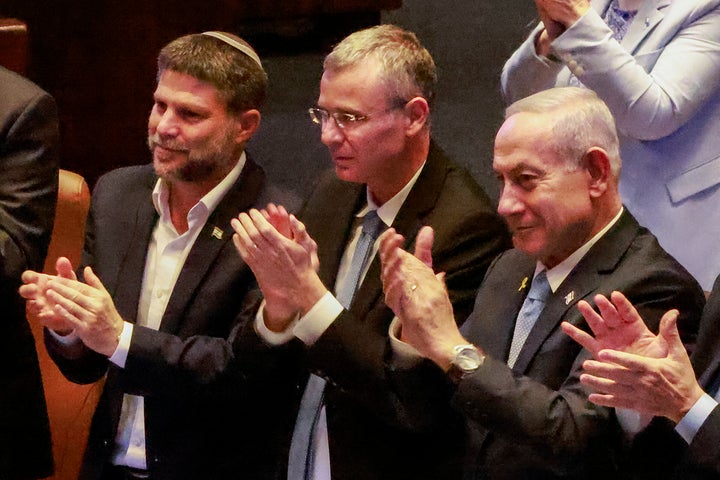 Israeli Finance Minister Bezalel Smotrich, Justice Minister Yariv Levin, and Prime Minister Benjamin Netanyahu applaud the address of Argentina's president before the Knesset at its headquarters in Jerusalem, on June 11, 2025.
