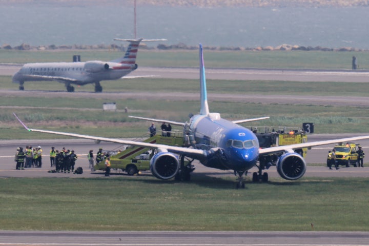 As equipes de emergência cercam um avião da JetBlue que rolou uma pista enquanto aterrissa no aeroporto de Logan, em Boston, na quinta -feira.