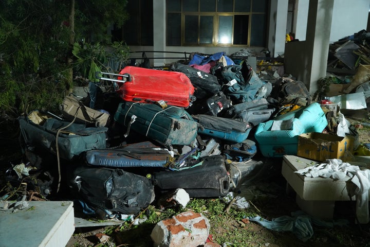 Luggage is piled Thursday near the crash site of a London-bound Air India flight in Ahmedabad, India.