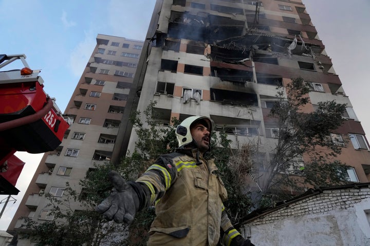 A firefighter calls out his colleagues at the scene of an explosion in a residence compound in northern Tehran, Iran, on June 13, 2025. 