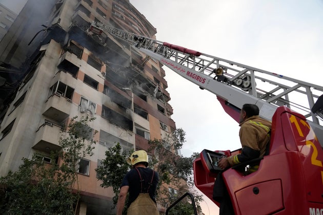 Firefighters work the scene of an explosion at a residence compound in northern Tehran, Iran, Friday, June 13, 2025. 