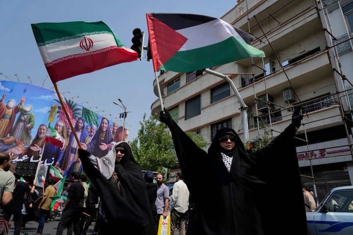 Iranian protesters hold up Iranian and Palestinian flags in an anti-Israeli gathering in Tehran, Iran, Friday, June 13, 2025. (AP Photo/Vahid Salemi)