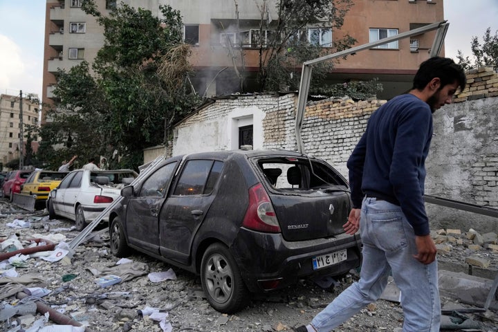 A man walks at the scene of an explosion in a residence compound in northern Tehran, Iran, Friday, June 13, 2025. (AP Photo/Vahid Salemi)