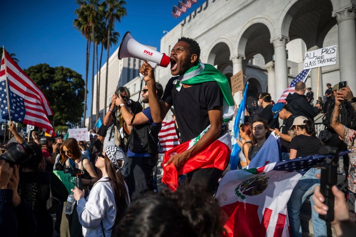 Um homem grita em um megafone fora da prefeitura durante protestos sobre os ataques federais de aplicação da imigração na quarta -feira, 11 de junho de 2025, em Los Angeles. (AP Photo/Ethan Swope)