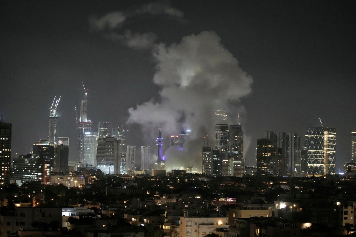 Smoke rises after a missile attack in Tel Aviv, Israel, Friday, June 13, 2025. (AP Photo/Leo Correa)