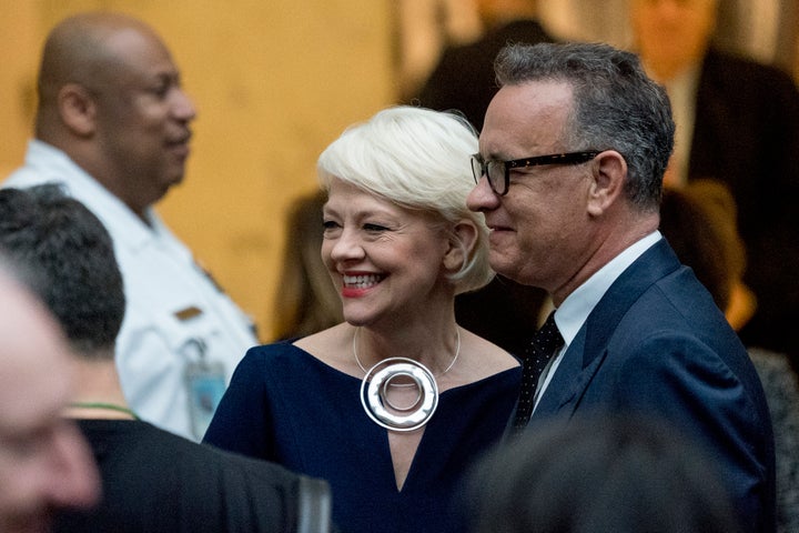 Kim Sajet, center, and actor Tom Hanks, right, pose for a photograph before a ceremony for the unveiling of the official portraits for former President Barack Obama and former first lady Michelle Obama in 2018.