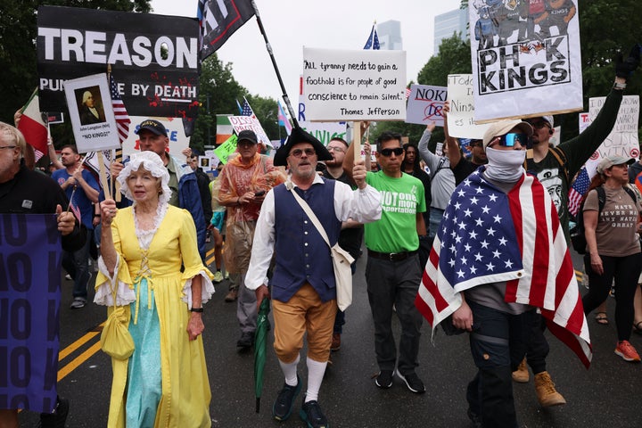Demonstrators dressed in Revolutionary War era clothing march down Benjamin Franklin Parkway during the "No Kings" protest, Saturday, June 14, 2025, in Philadelphia.